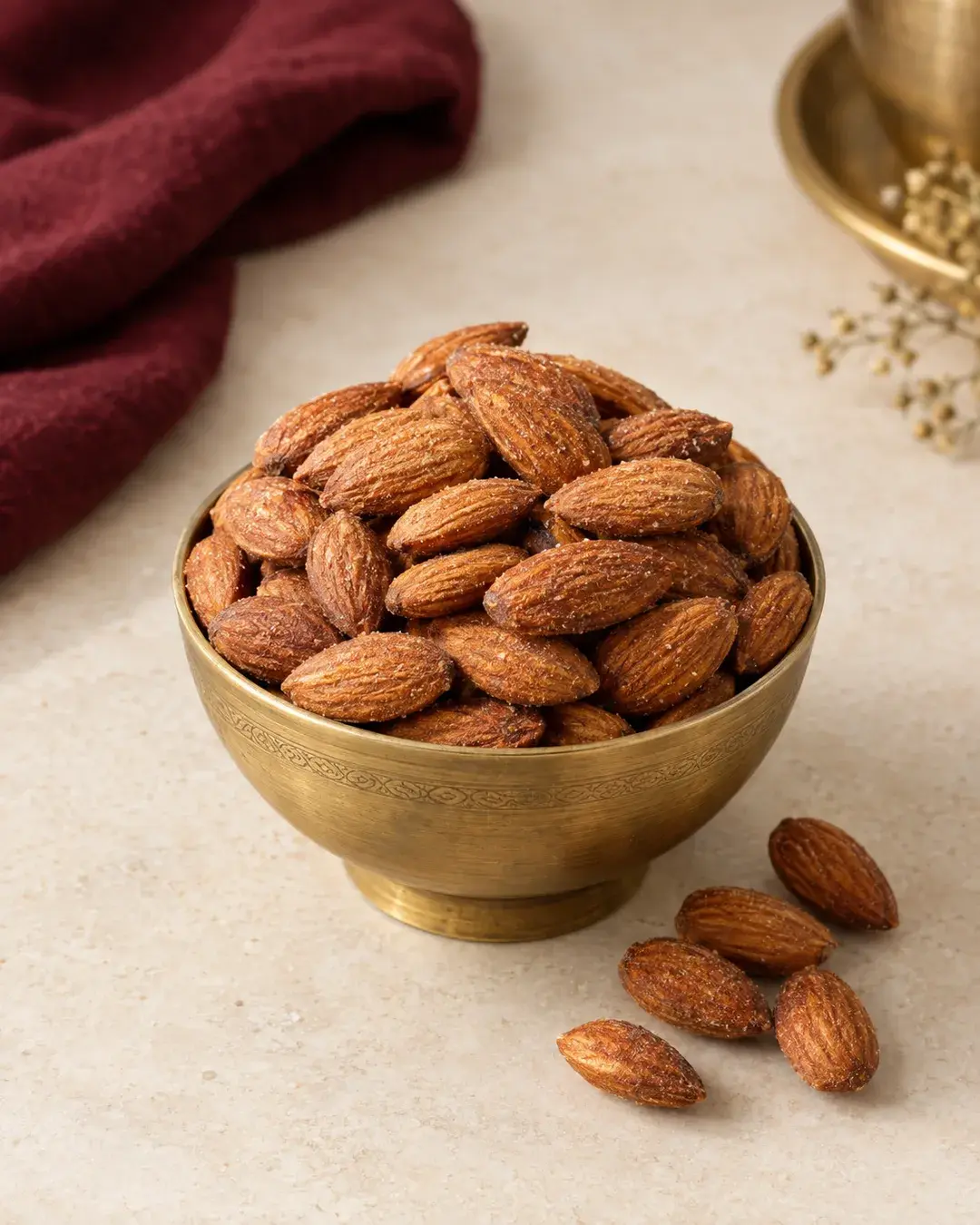Whole roasted almonds heaped in a small brass bowl